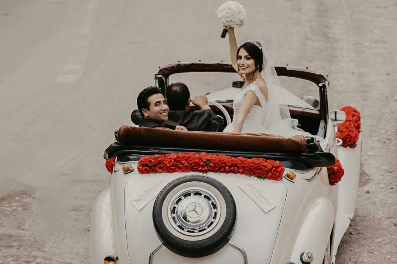 a married couple riding in a car together to elope after their wedding
