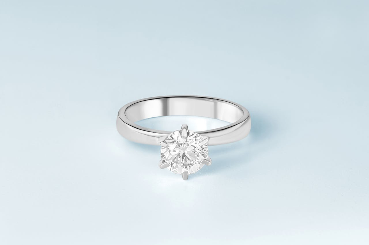 A white gold solitaire engagement ring with a round cut center diamond.