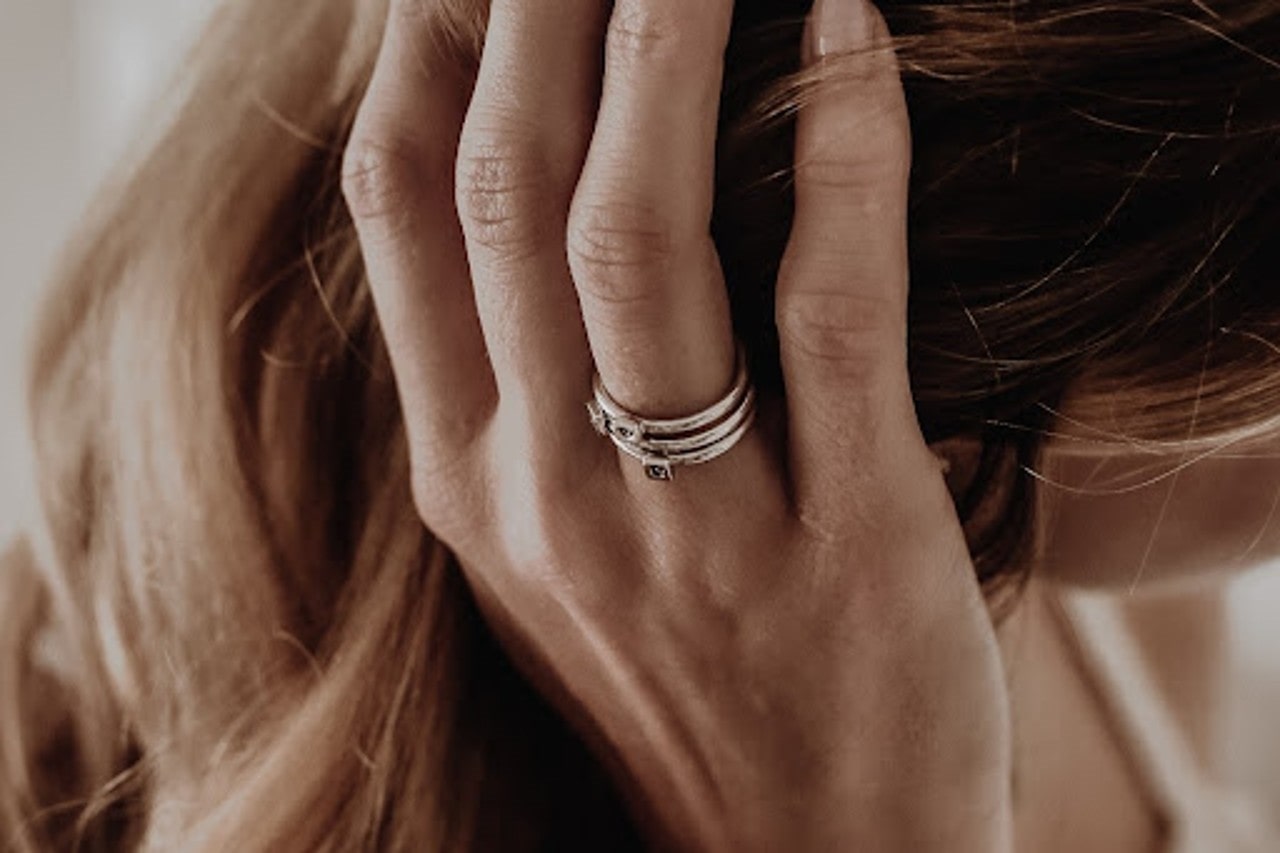 lady’s hand holding her hair and wearing a beautiful fashion ring