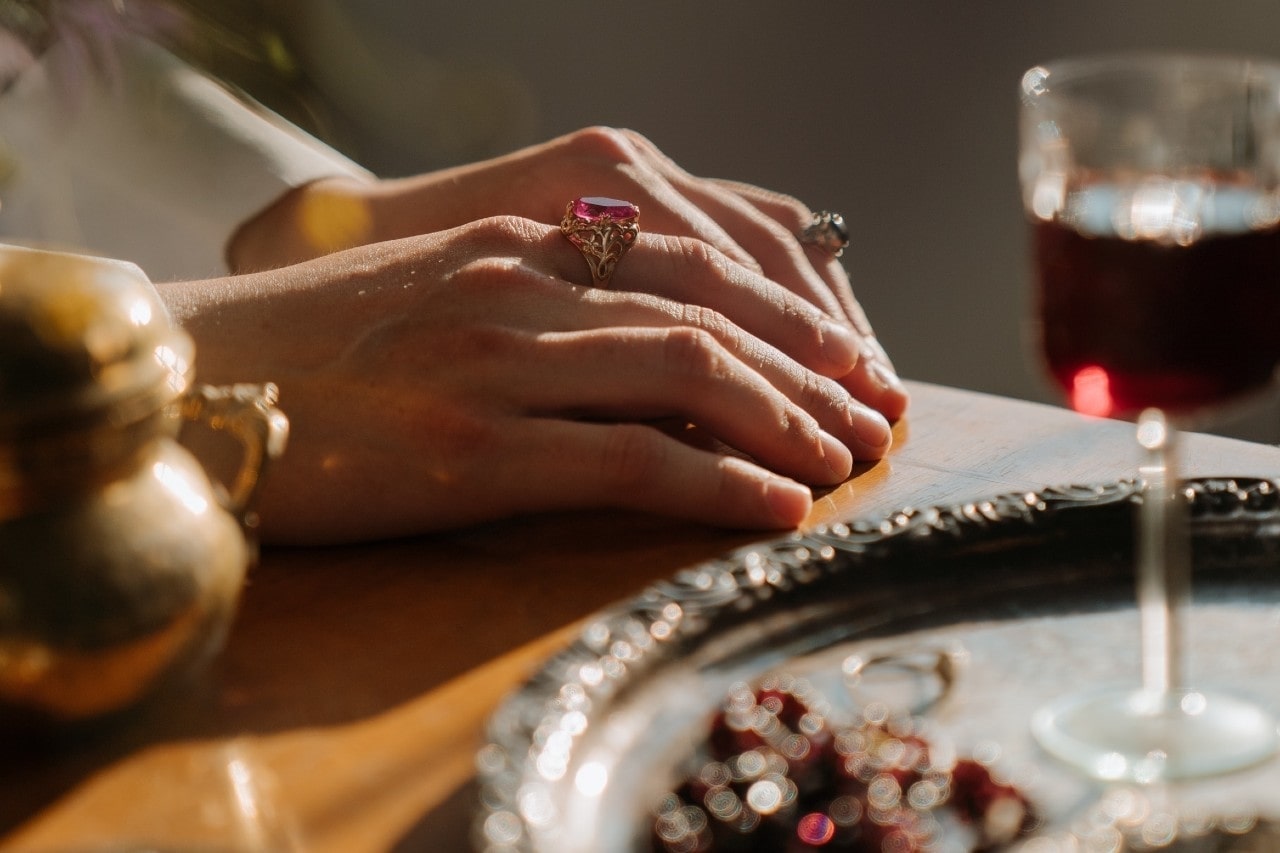 lady’s hands wearing fashion rings and resting on a table