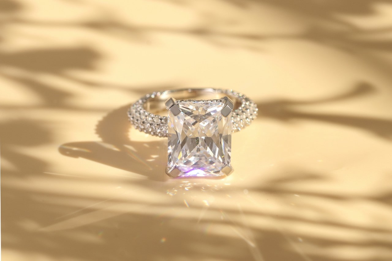 a radiant cut engagement ring sitting on a yellow surface a radiant cut engagement ring sitting on a yellow surface
