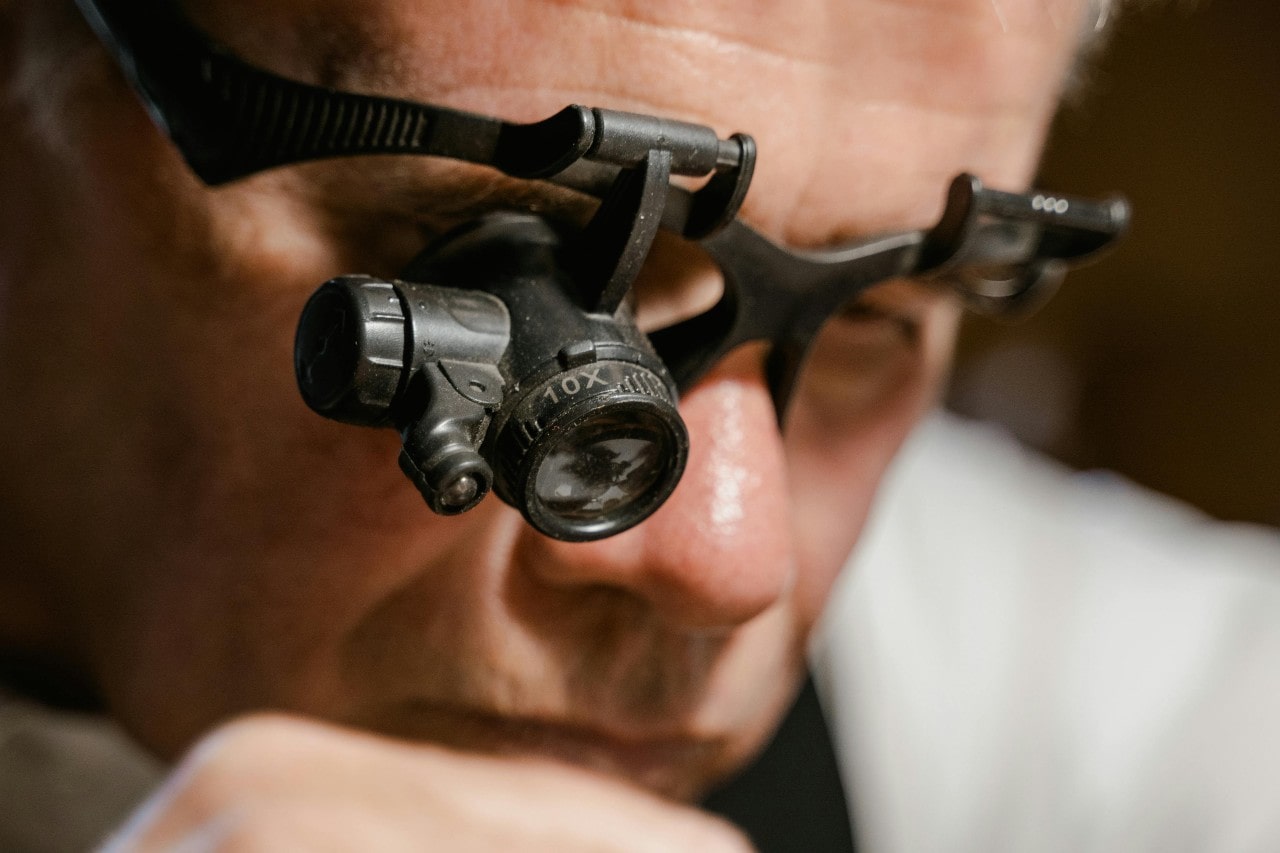 A jeweler with magnifying glasses inspecting something